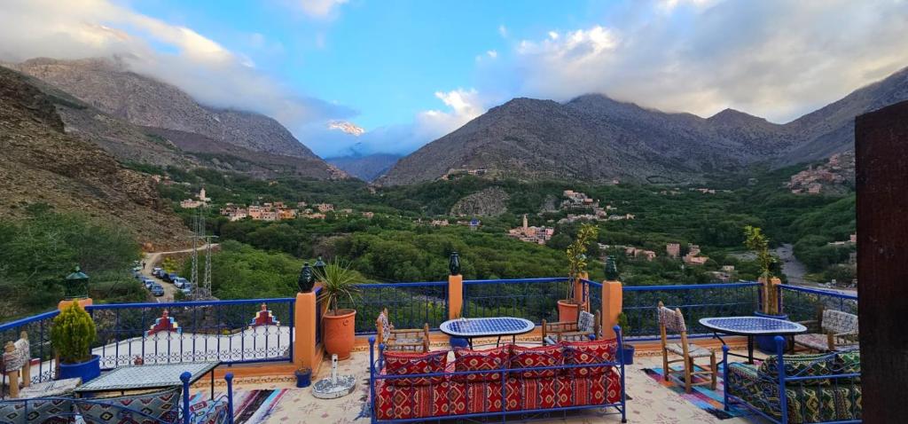 a balcony with tables and chairs and a view of mountains at Riad Dar Omar in Imlil