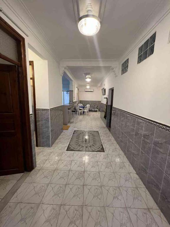 an empty hallway with a tile floor and a room at Residence el baraka in Bou Zadjar