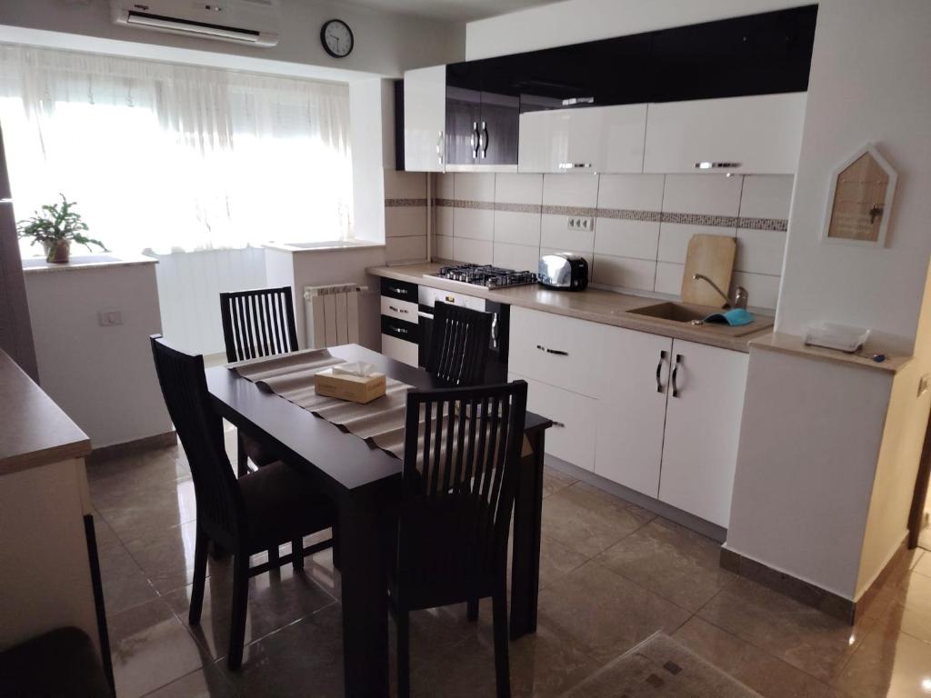 a kitchen with a table and chairs in a room at Apartament Centru in Râmnicu Vâlcea