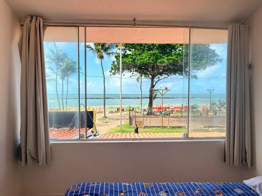 a bedroom with a window with a view of the ocean at Praia do Frances - Casa Vista para o Mar - 50 metros da areia da praia in Praia do Frances