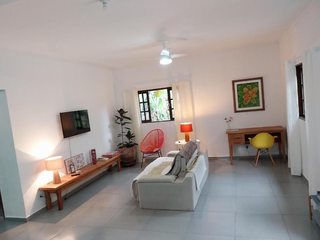 a living room with a couch and a tv at Casa da matta in Ubatuba