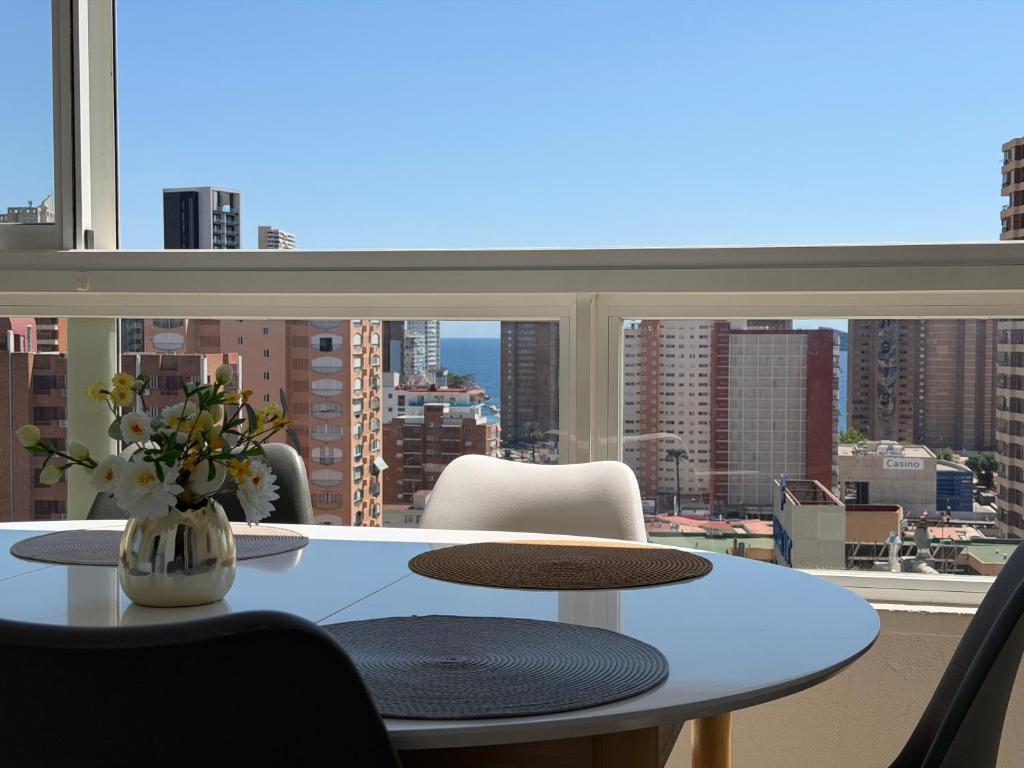 a table and chairs in a room with a large window at Gemeleos22 in Benidorm