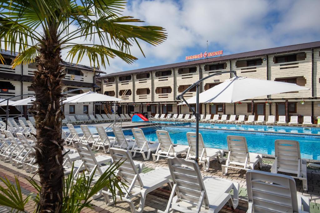 a group of chairs and umbrellas next to a pool at Золотий Павлін in Solotvyno