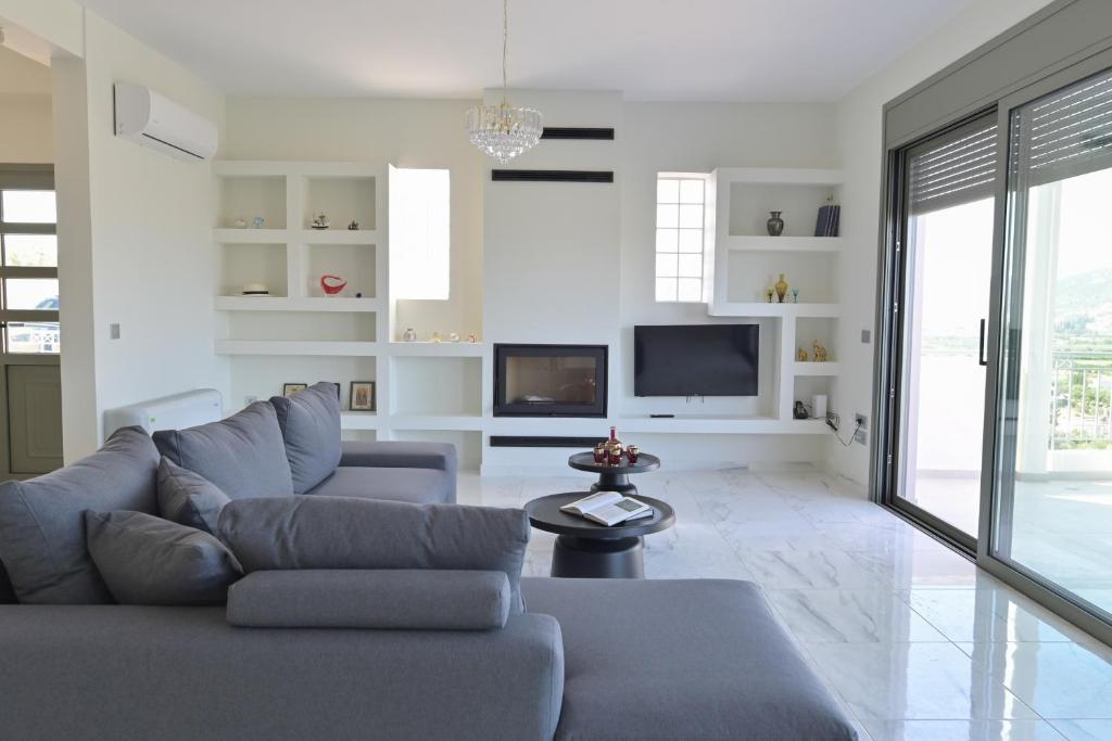 a living room with a couch and a tv at VILLA GALINI NAFPLIO with Panoramic View I in Nafplio