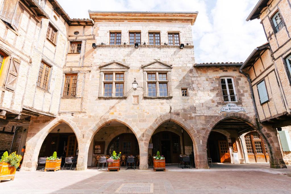 an old stone building with arches and windows at Hotel des Consuls in Castelnau-de-Montmiral
