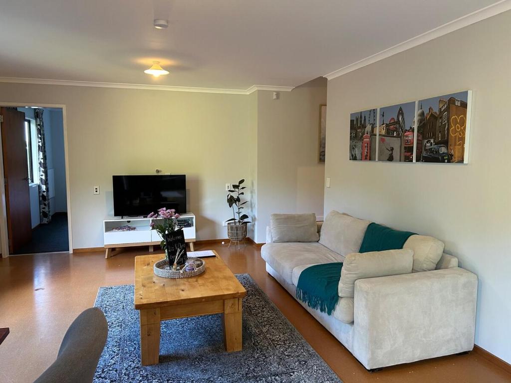 a living room with a white couch and a table at Spacious peaceful apartment in Wellington