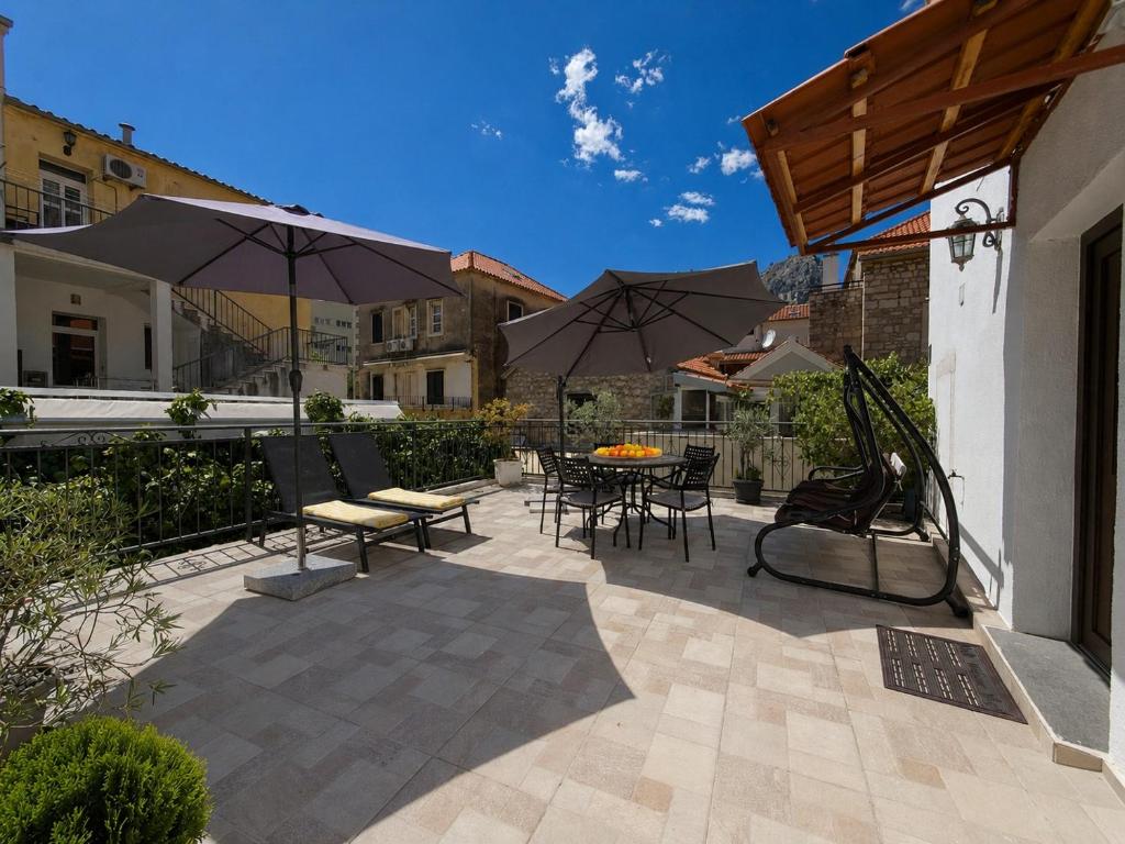 a patio with umbrellas and a table and chairs at Apartment Romić in Omiš