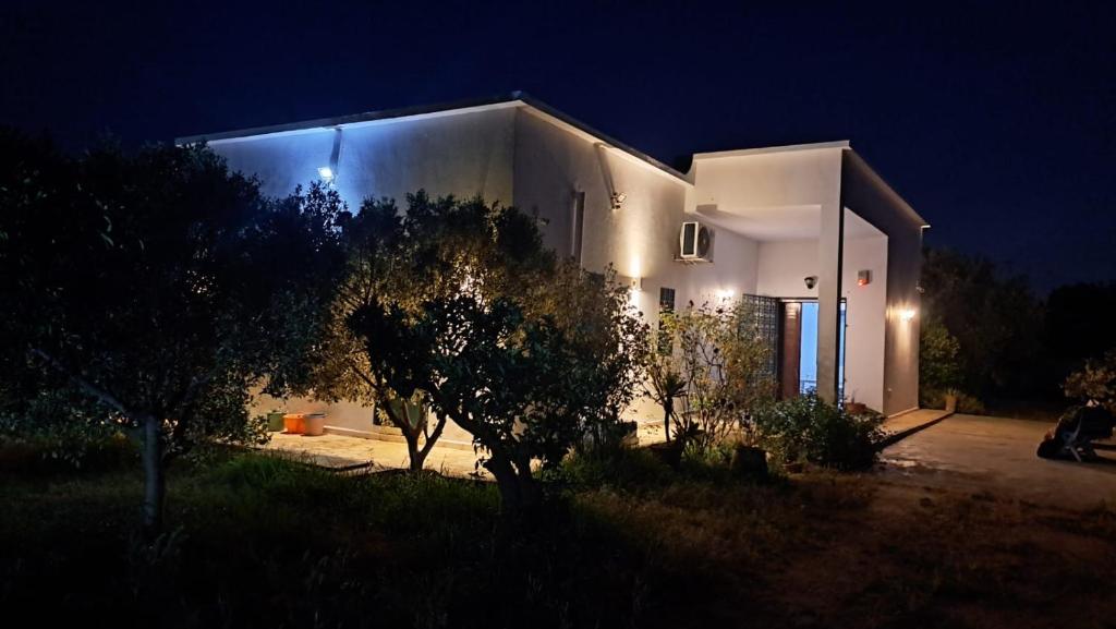 a large white building with lights on it at night at Dar Zakia in Soliman