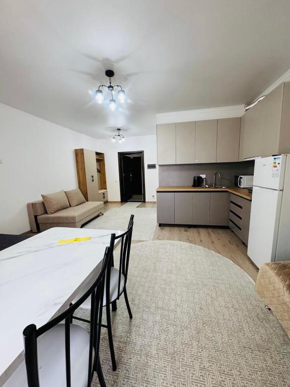 a kitchen and living room with a table and a refrigerator at Raduga West Balor in Koshkolʼ