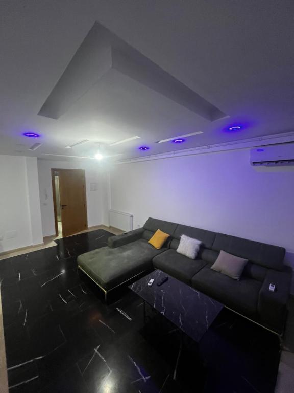 a living room with a black couch and purple ceilings at Sweethome in Ariana