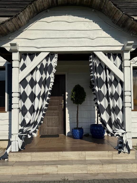 a porch with a black and white checkered curtain at Domek nad jeziorem in Kikół