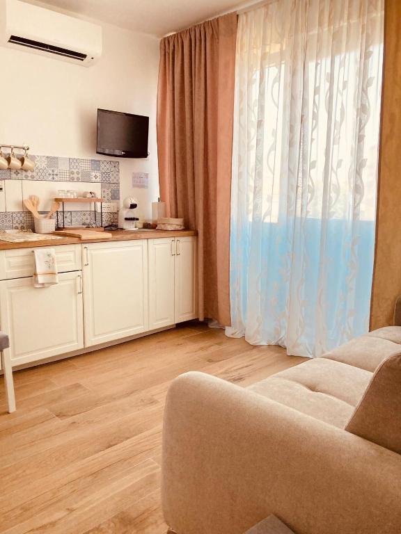 a living room with a couch and a kitchen at Casa Di Luce Junior Con Parcheggio Privato in Montesilvano