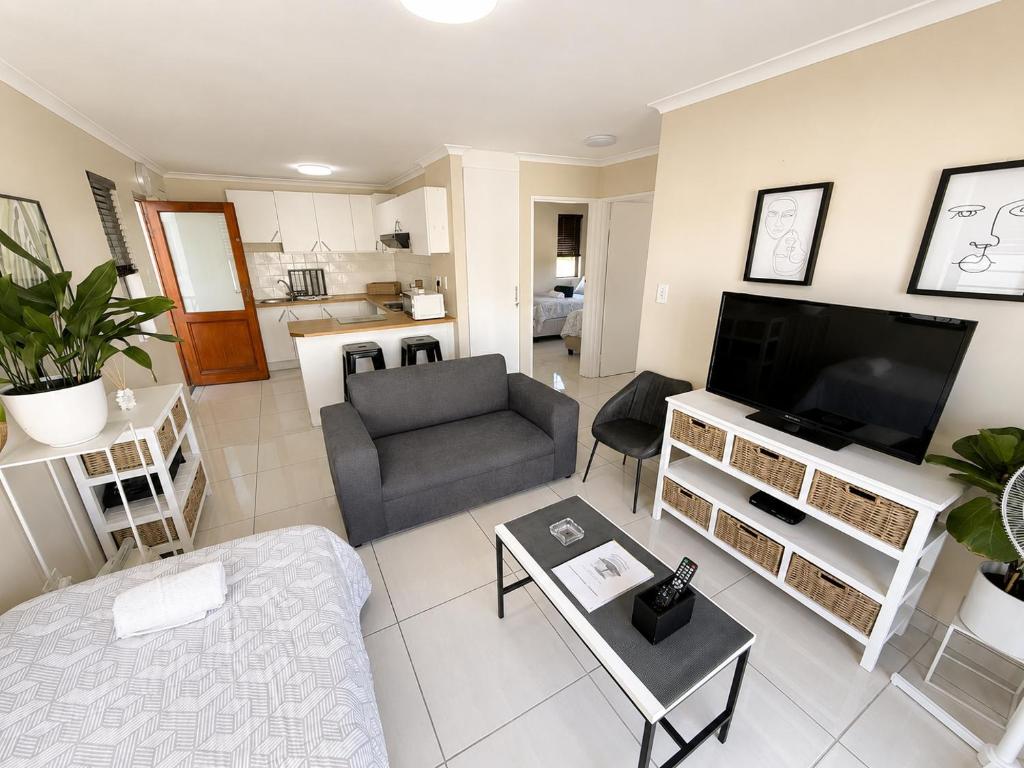a living room with a couch and a television at Unit 5 in Serengeti Complex, Bloemhof, Bellville in Blomtuin
