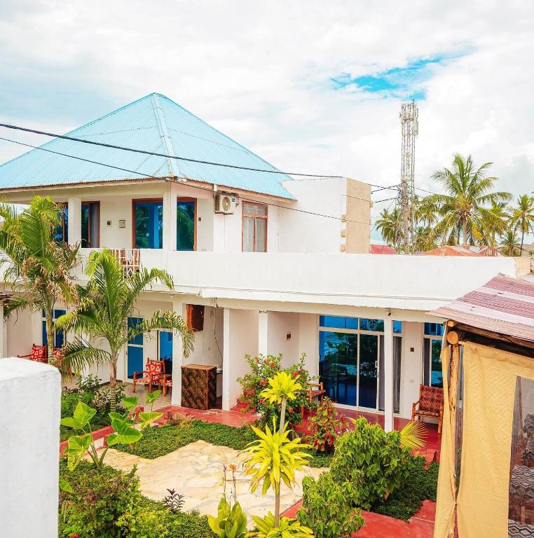 a house with a blue roof at Karibu House Paje in Paje