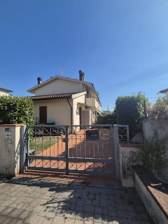 a gate in front of a white house at La Casina in Pontedera