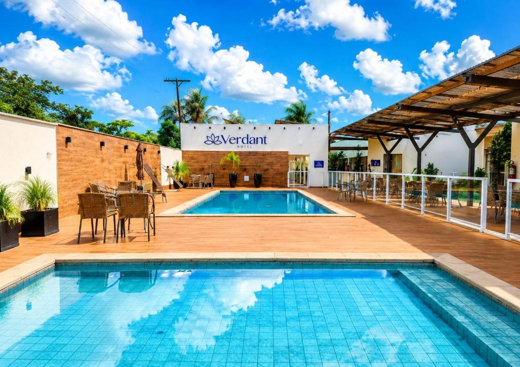 a swimming pool with a patio and a building at Verdant hotel in Bonito