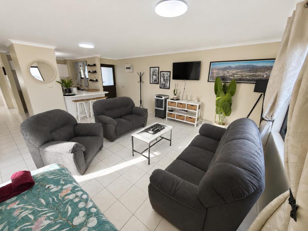a living room with two couches and a table at Serengeti Heide Self Catering Flats in Cape Town