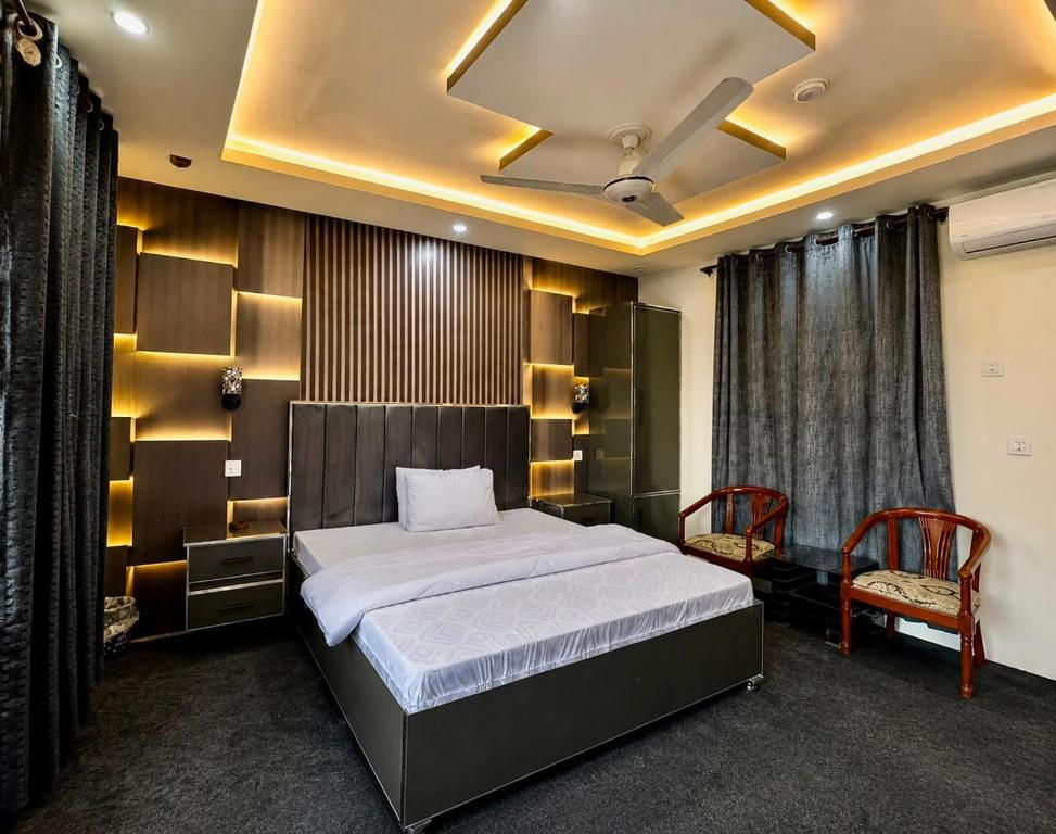 a bedroom with a large bed and two chairs at The Comfy By Hotel Mountain Track in Taranna