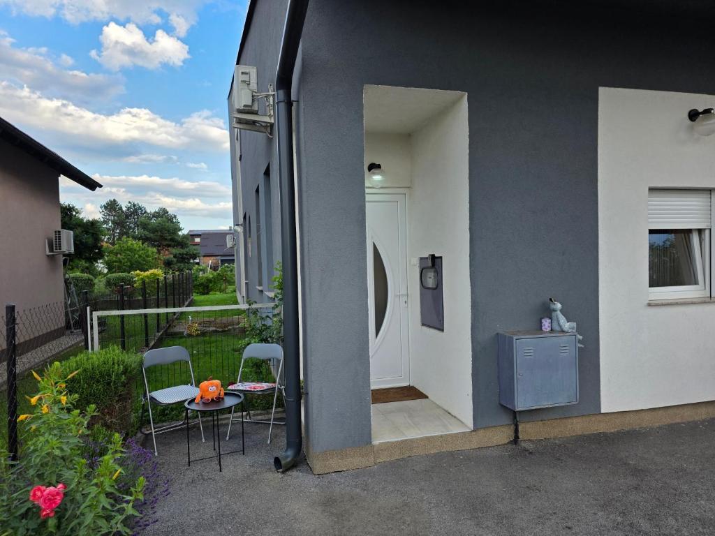 a side view of a house with a table and chairs at apartmani mikek in Domaslovec