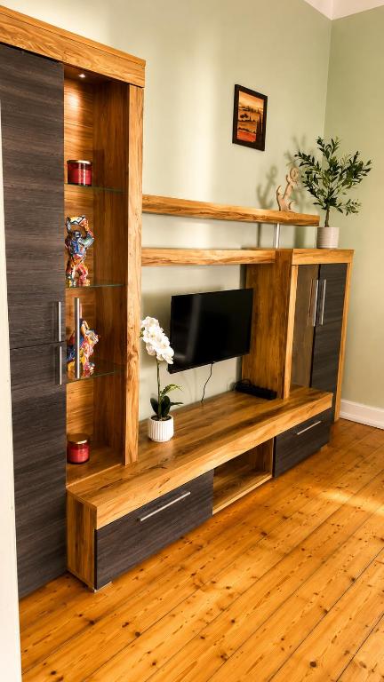 a entertainment center with a television in a living room at Pension zum Ziegenbart in Tangermünde