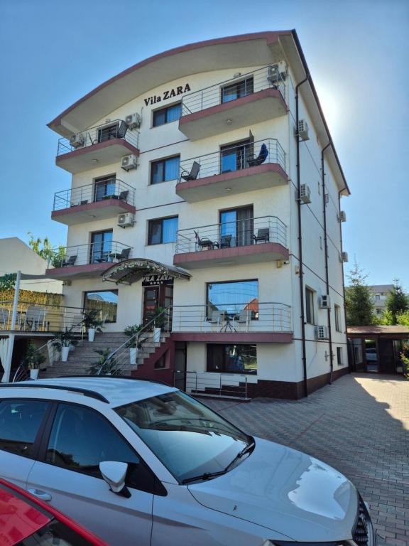 a building with a car parked in front of it at Vila Zara in Mamaia Sat/Năvodari