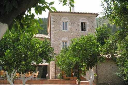 a large stone house with trees in front of it at Pyrgos Of Mystra in Mystras