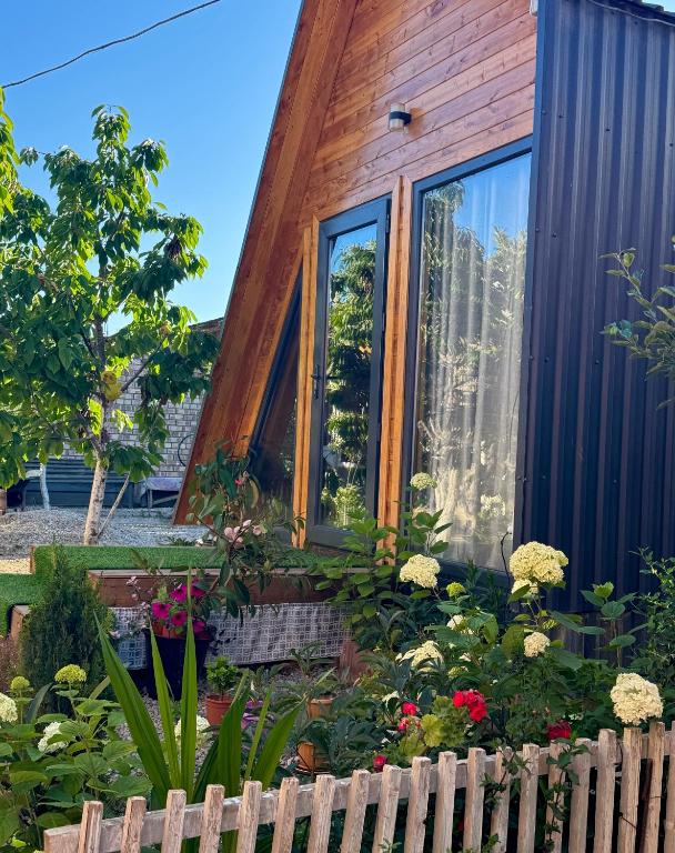 a tiny house with flowers in front of it at Bayaman Guest House in Bokonbayevo