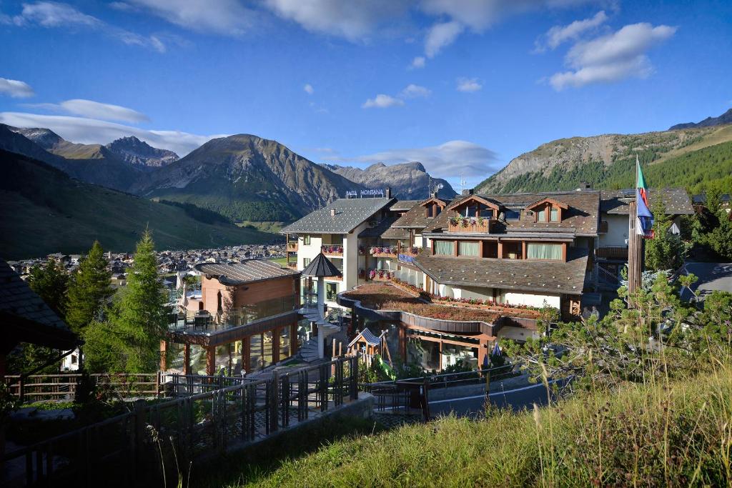 a resort in the mountains with mountains in the background at Hotel Baita Montana in Livigno