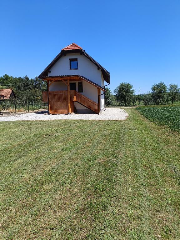 a small building with a grass field in front of it at M&M house in Bizeljsko