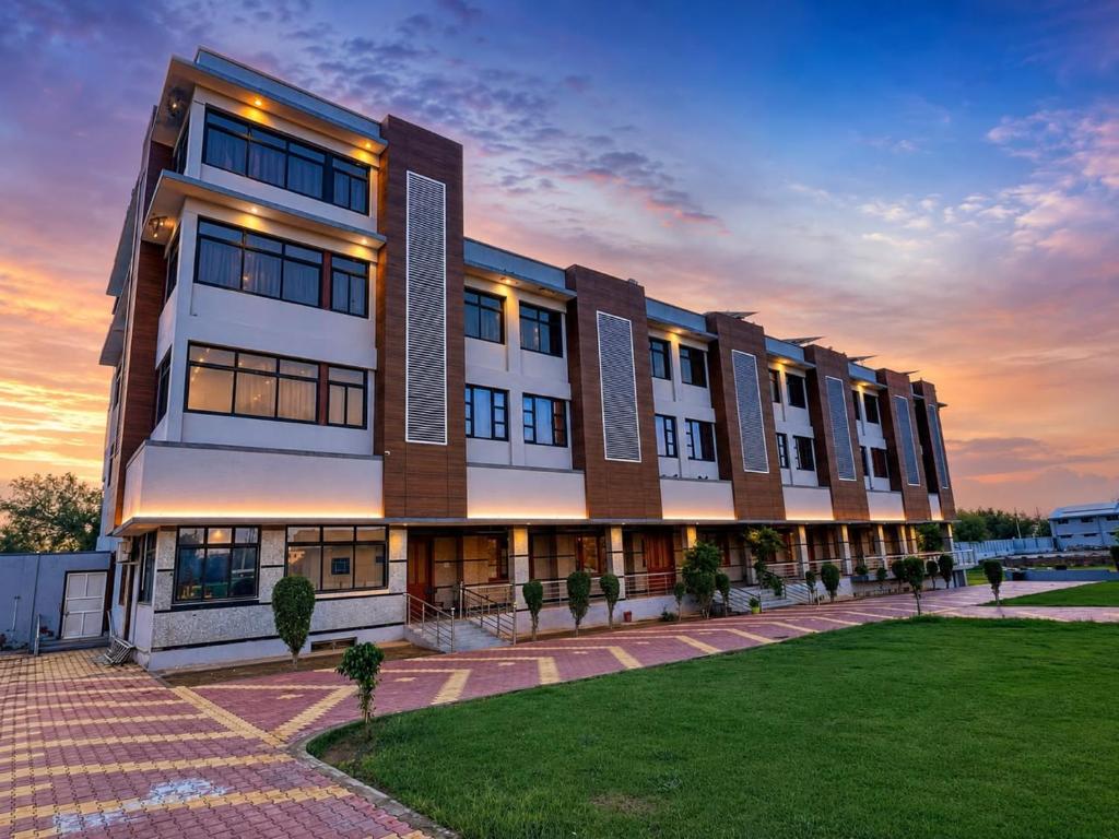 a large building with a lawn in front of it at Bits Pilani Resort in Bagar