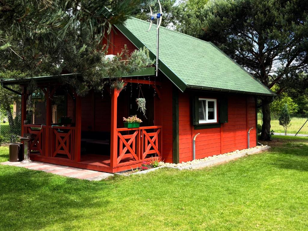 a red shed with a green roof at Zielone okiennice in Chobie