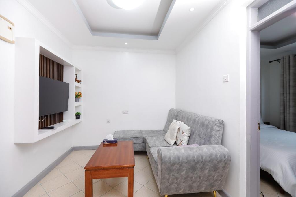 a living room with a chair and a table at Modern Guest House 2BR in Nakuru