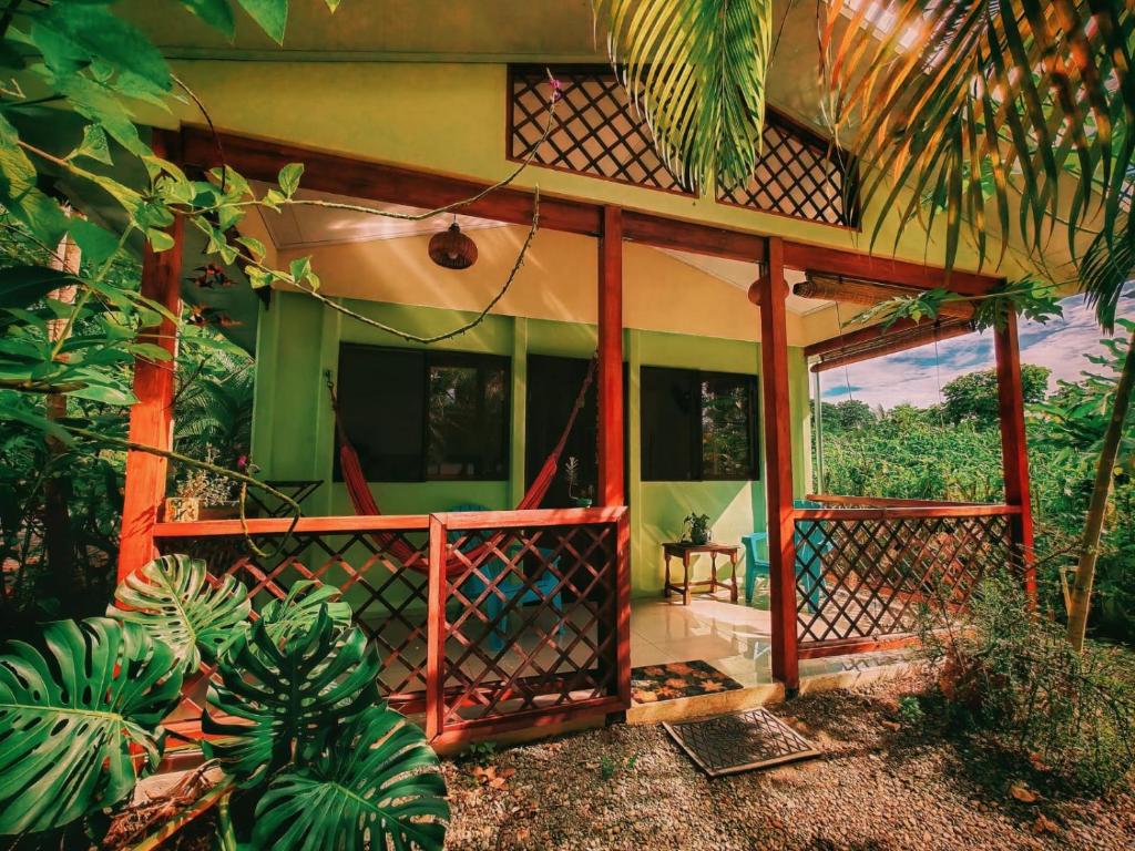 a house with a screened in porch in a forest at Casa Farolito Rodeada de naturaleza y paz in Hone Creek