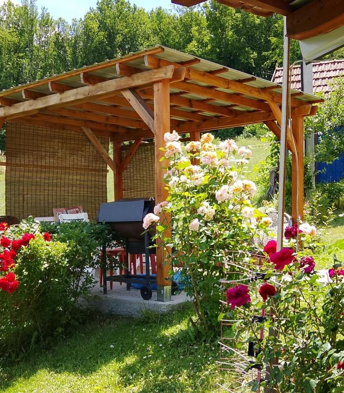 a wooden pergola with a bench in a garden at Kuća Despot in Kremna