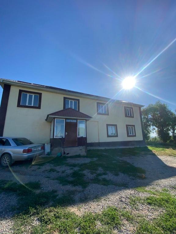 a house with a car parked in front of it at Panorama in Karakol