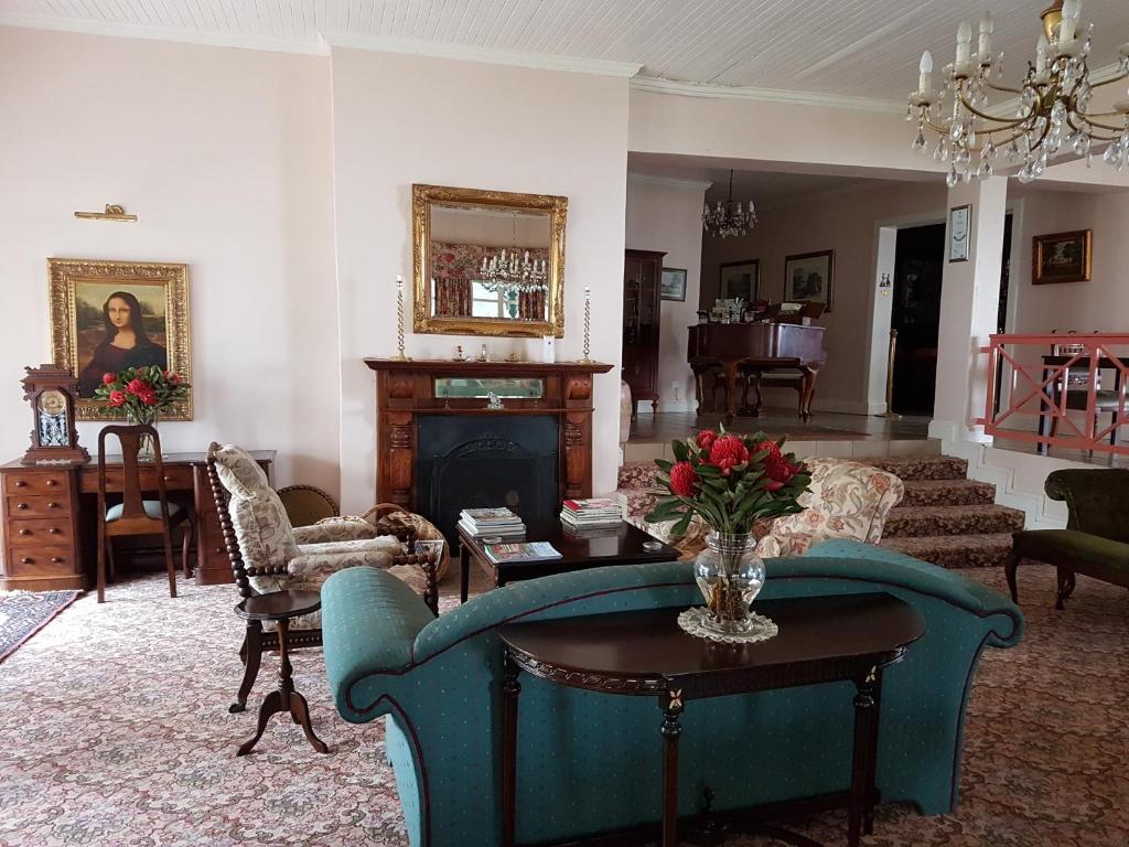 a living room with a blue couch and a fireplace at Sherwood's Country House in Tzaneen