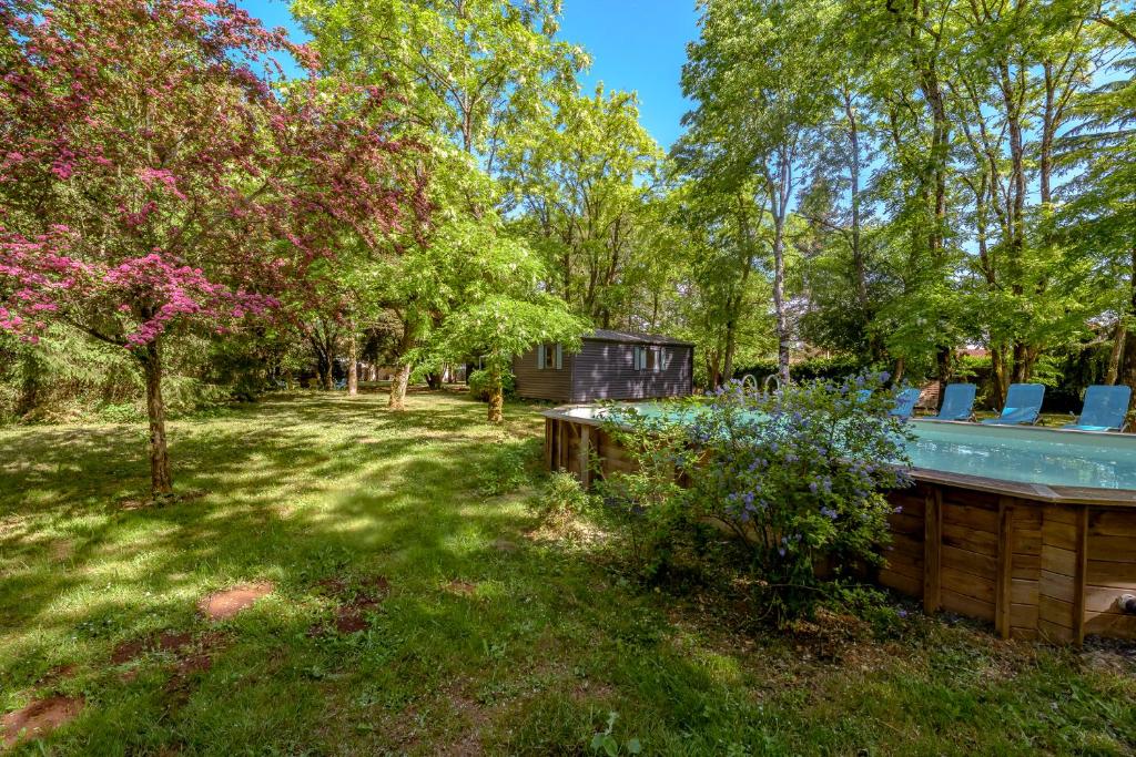 a yard with a house and trees at Manoir le Mingreaud Bungalows in Sainte-Gemme-la-Plaine
