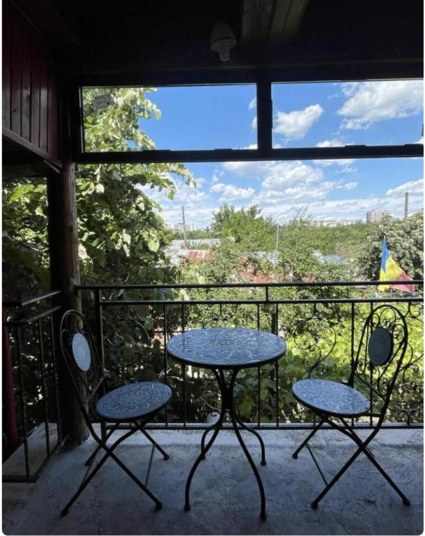 a table and two chairs on a balcony with a view at Happy Home in Bucharest