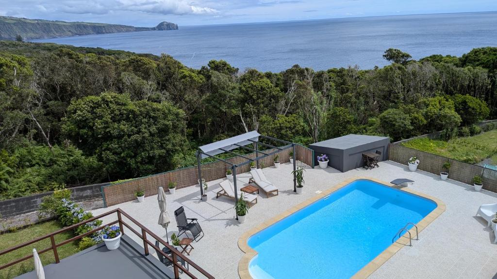 an outdoor swimming pool with a view of the ocean at Villa Capelinhos in Capelo