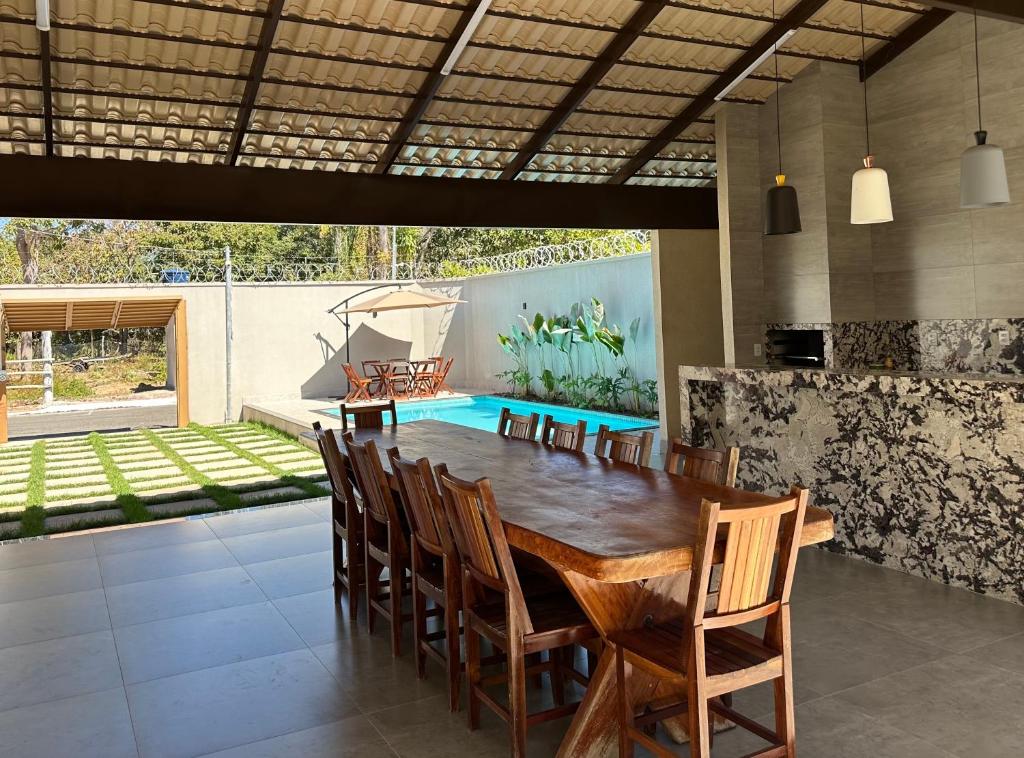 a dining room with a wooden table and chairs at Residência Araguaia in Aruanã