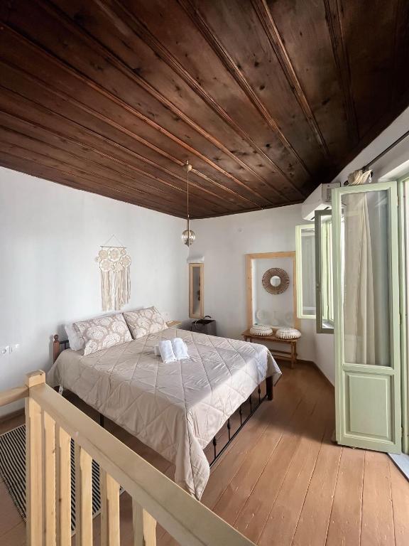 a bedroom with a large bed and a wooden ceiling at Happiness skopelos in Glossa