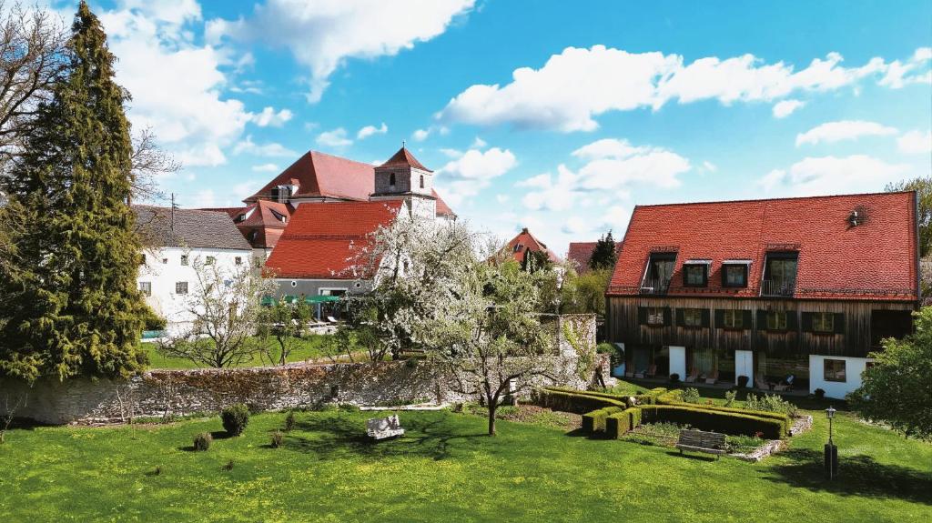 a group of buildings in a green yard with trees at Romantik Hotel Zum Klosterbräu in Neuburg an der Donau