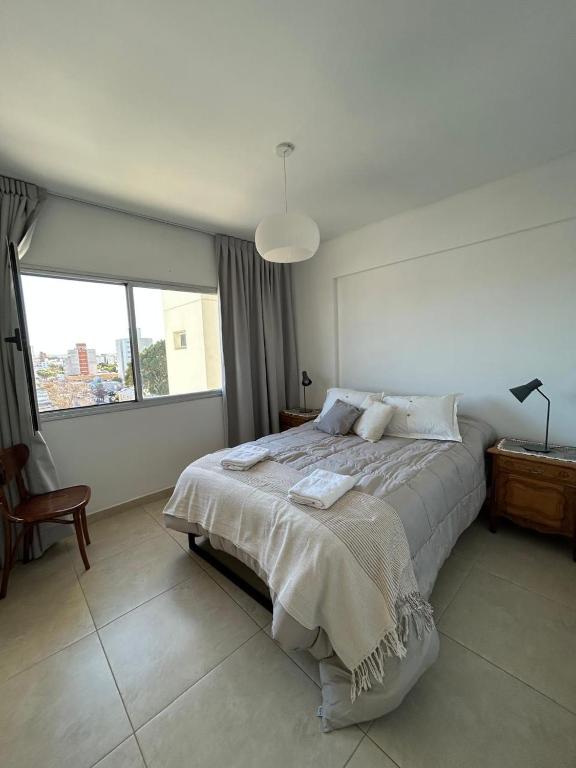 a bedroom with a bed and a large window at Refugio Centro in Puerto Madryn