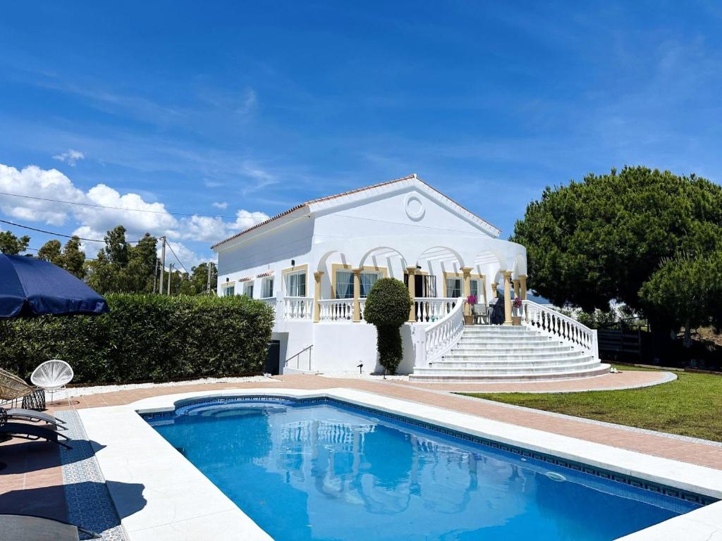 a house with a swimming pool in front of a building at Villa El Dorado in Estepona