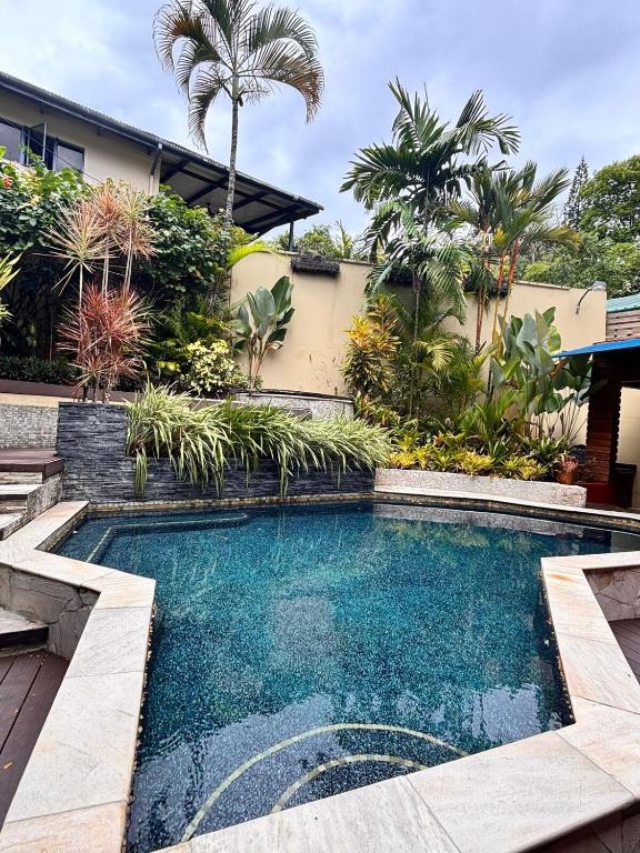 a swimming pool in front of a house at Serenity Garden Escape in Port-of-Spain