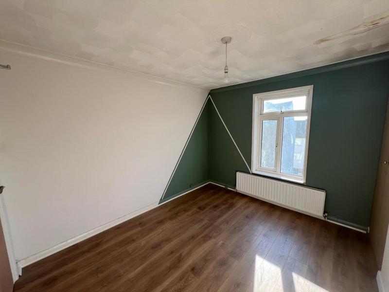 an empty room with a green wall and a window at Gravesend Central - Spacious & Quiet Rooms in Gravesend