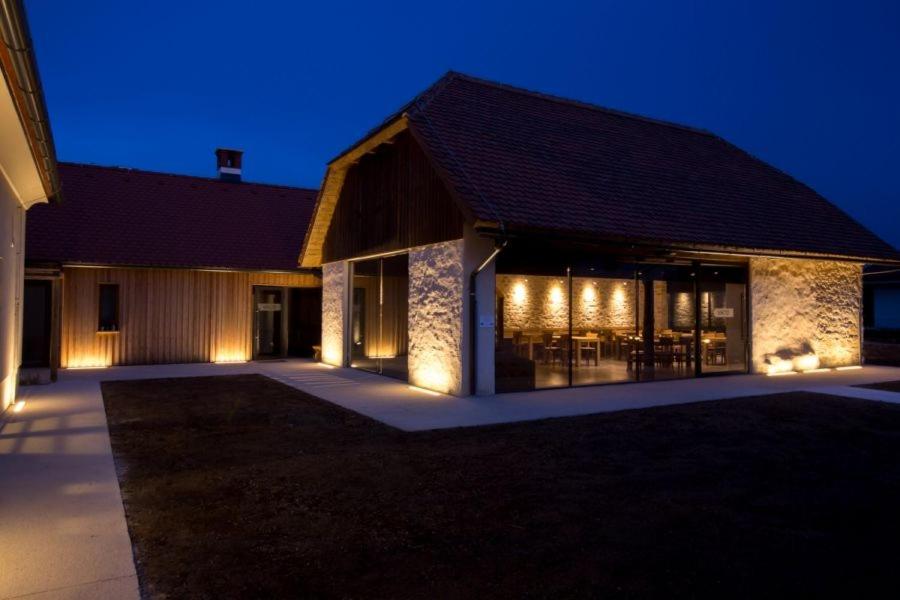 a building with lights on the outside at night at Smrekarjeva Domačija in Postojna