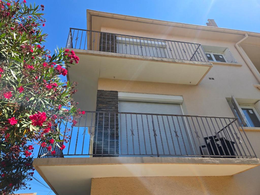 an apartment building with a balcony with pink flowers at Yamna in Perpignan