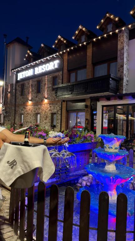 a fountain in front of a hotel at night at Jeton Resort in Çerenec i Poshtëm