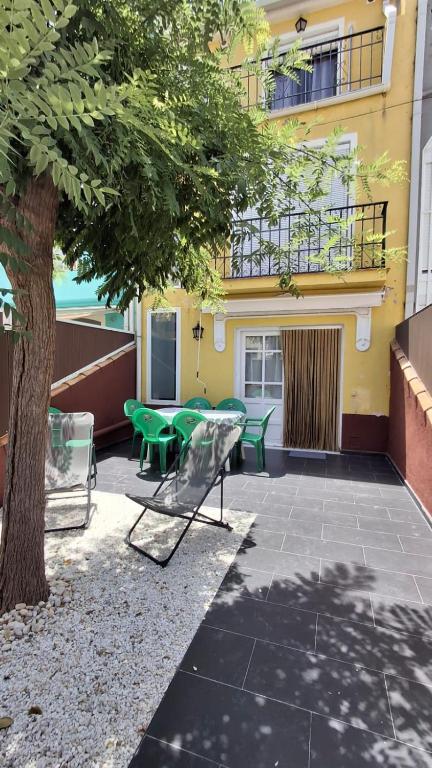 a patio with chairs and a tree in front of a building at Villaparadisi in Benicàssim